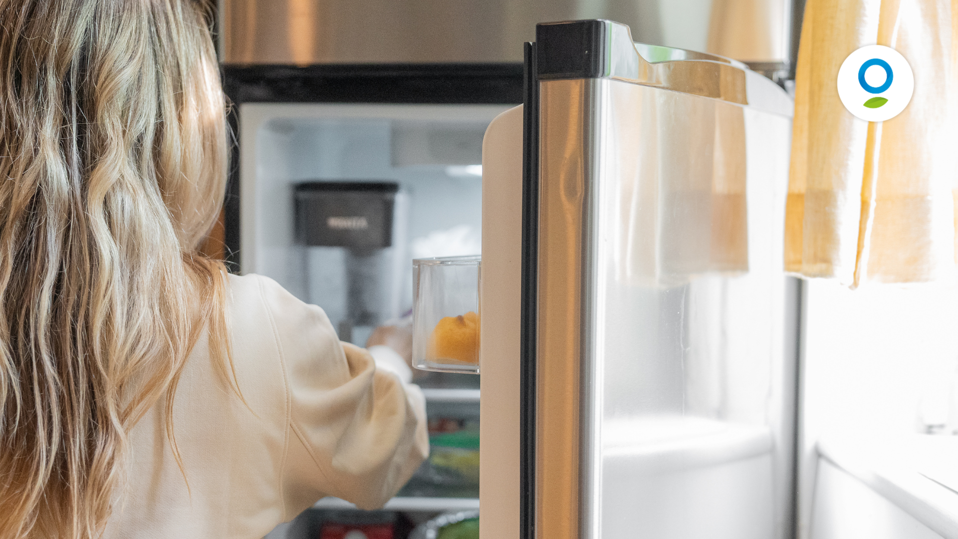 ragazza che apre il frigo per prendere del cibo